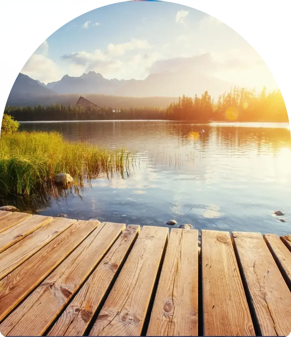 Sunset over a peaceful lake with mountains in the background.