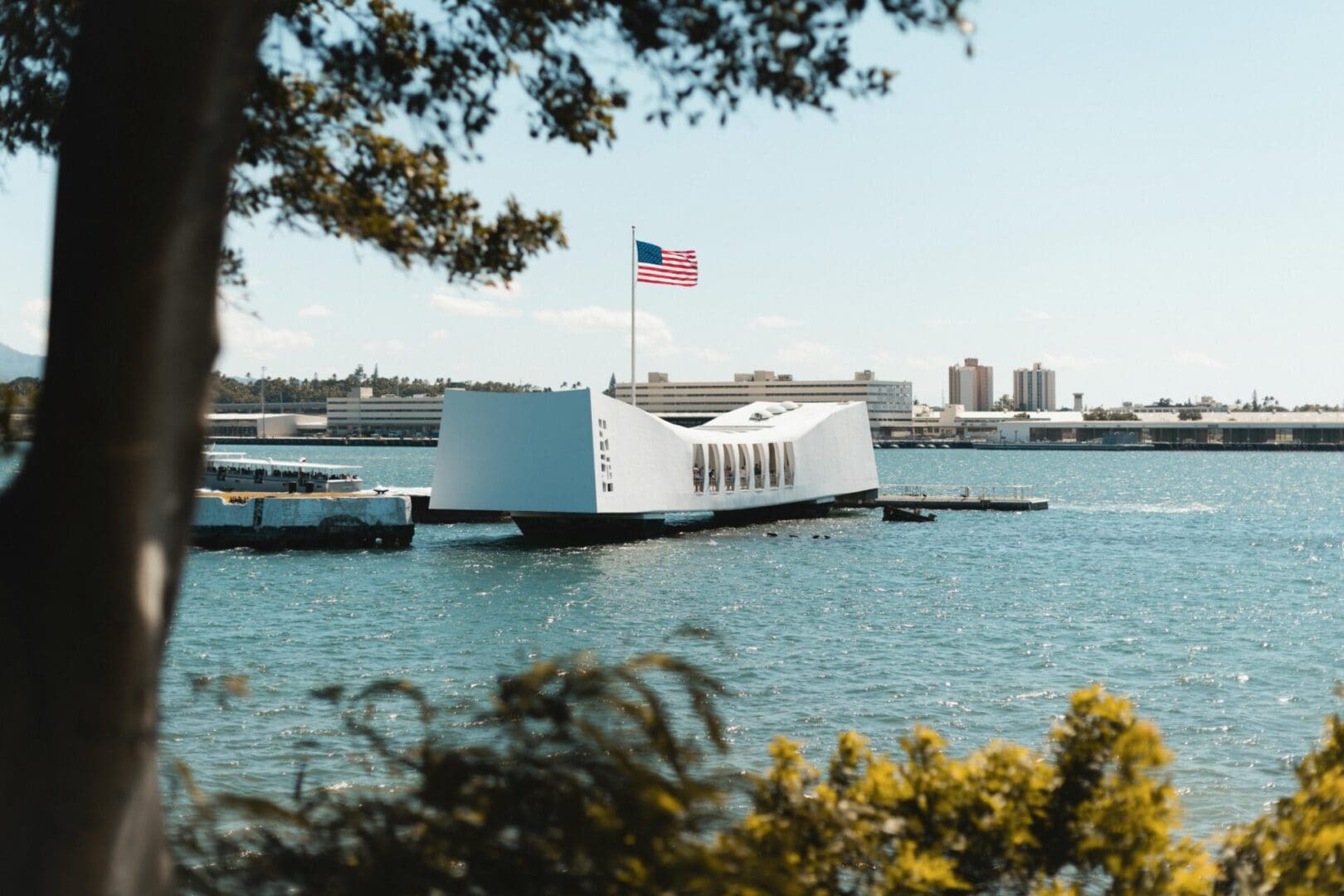 The USS Arizona Memorial in Pearl Harbor with an American flag.