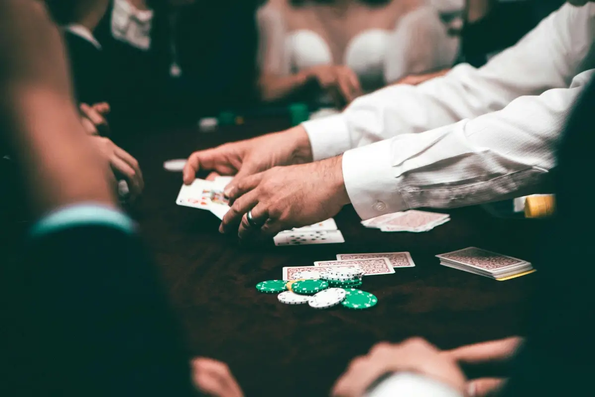 People playing poker with chips and cards on the table.