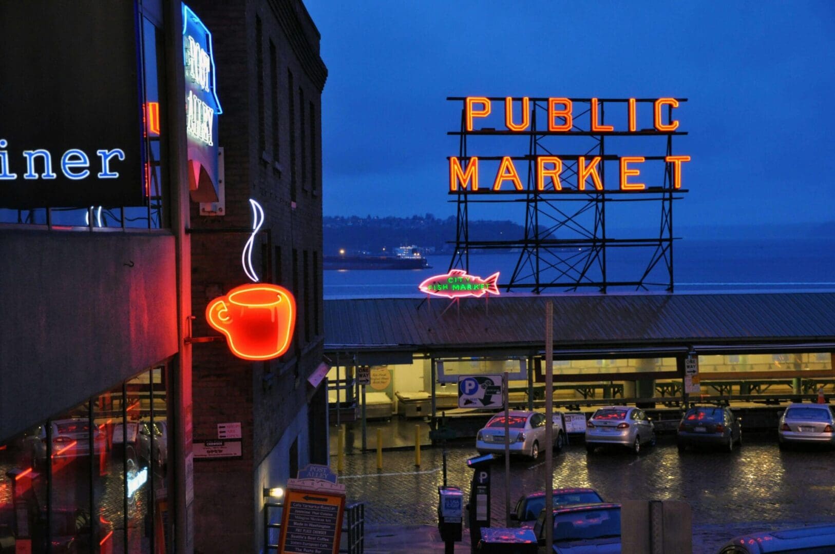 Night view of a bustling public market entrance with neon signs.